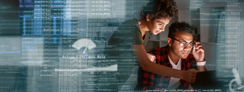 Young Indian Developer And His Project Manager Discussing Application Code